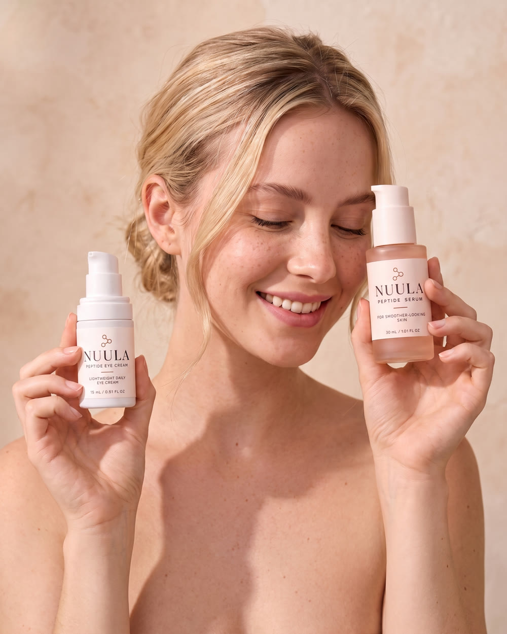 A woman holding the NUULA Peptide Serum and Eye Cream